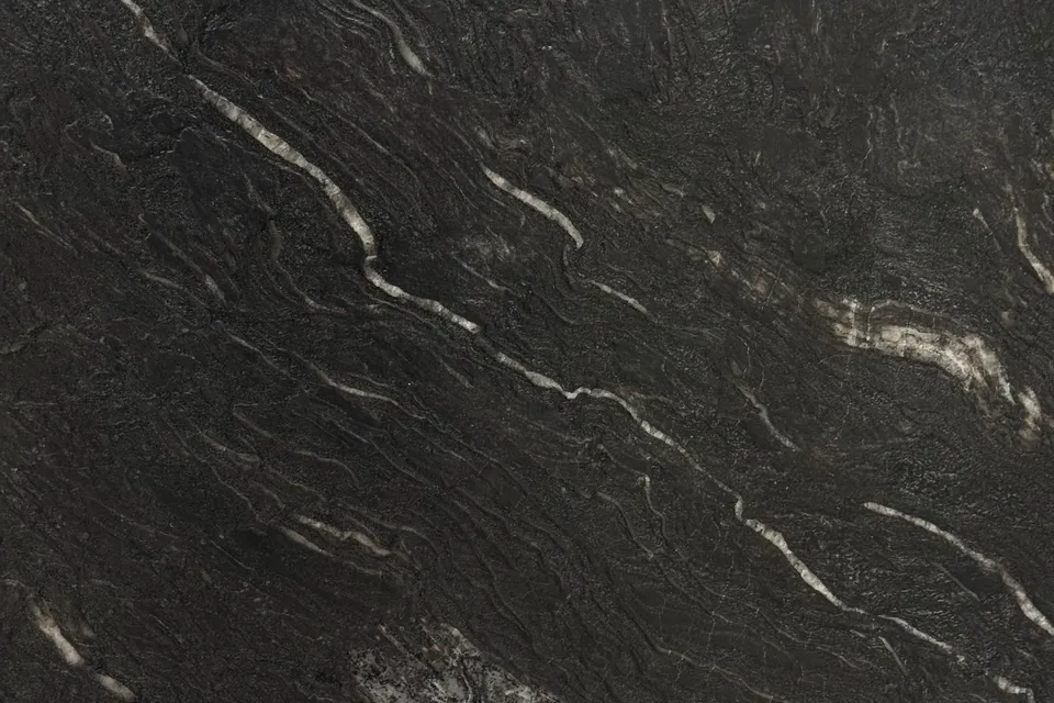 Near-black textured slab with thin cream streaks running diagonally across a rippled surface
