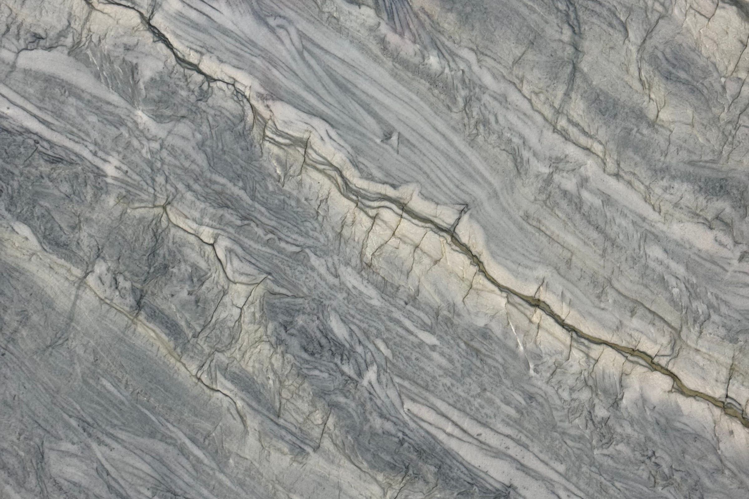 Blue-gray stone with cream bands and thin dark crinkled lines running diagonally upward