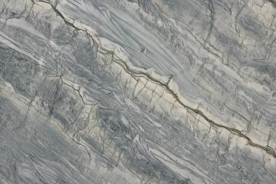Blue-gray stone with cream bands and thin dark crinkled lines running diagonally upward