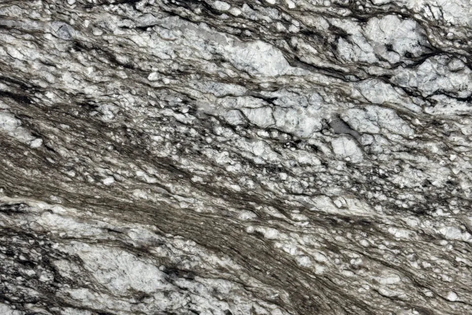 Gray and white crystalline granite with dark brown and black streaks running from upper left to lower right
