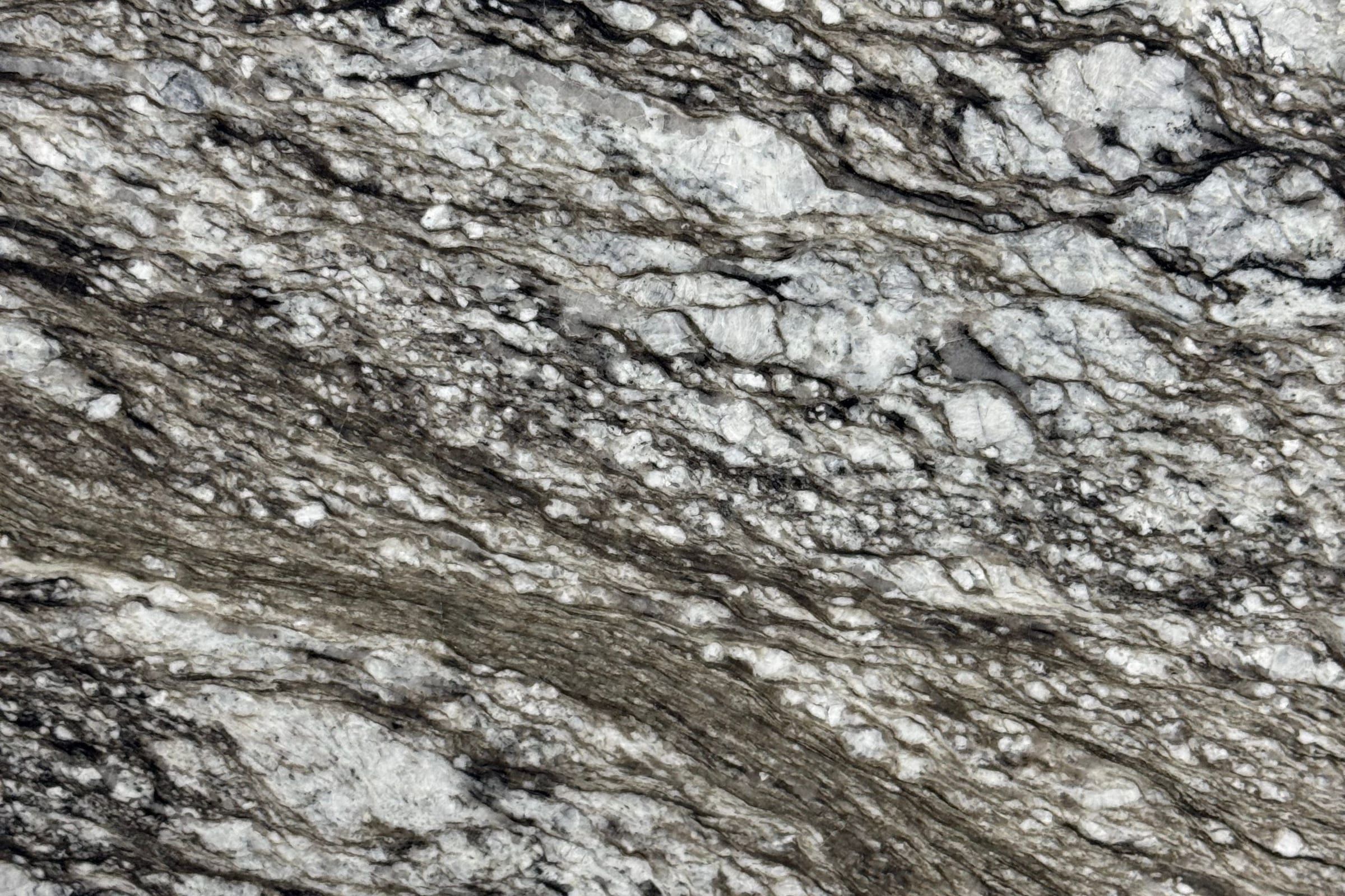 Gray and white crystalline granite with dark brown and black streaks running from upper left to lower right