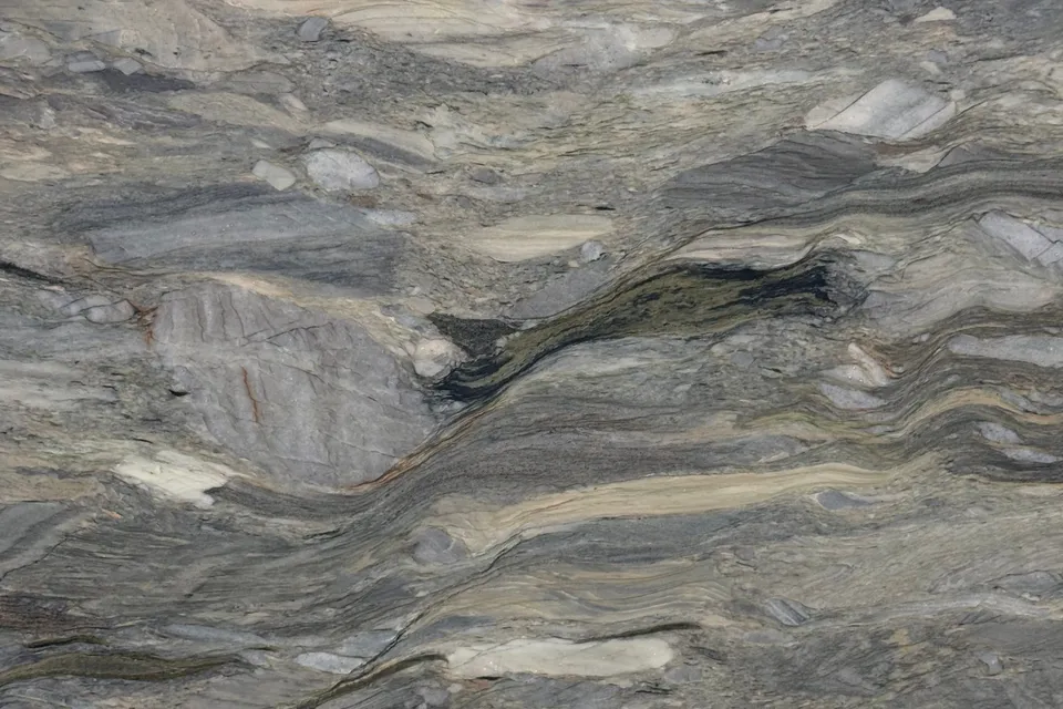 Swirled gray, tan and brown layers with rounded pale fragments across the whole slab